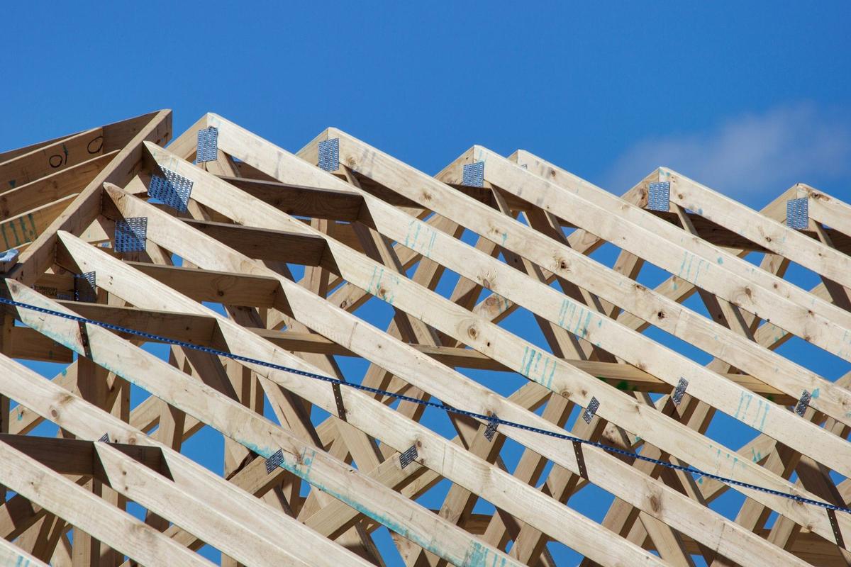 Houten dakspanten tegen een blauwe lucht